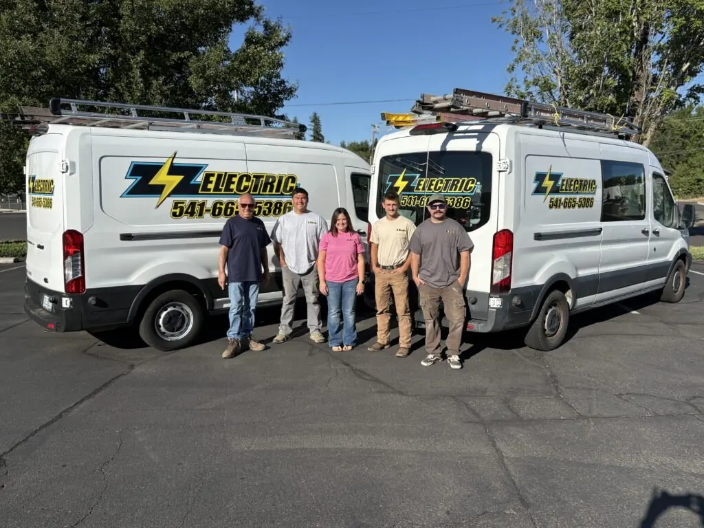 ZZ Electric crew standing beside the company service vans