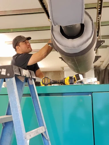 Technician working on generator exhaust equipment